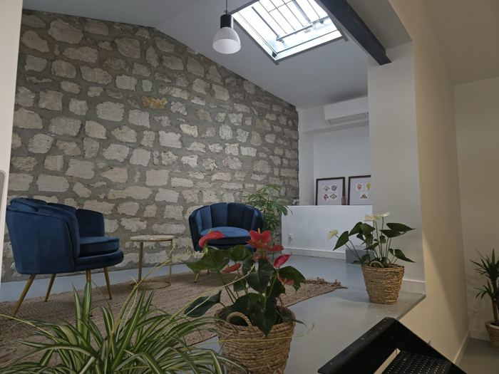 Fauteuils, mur en pierre et verrière