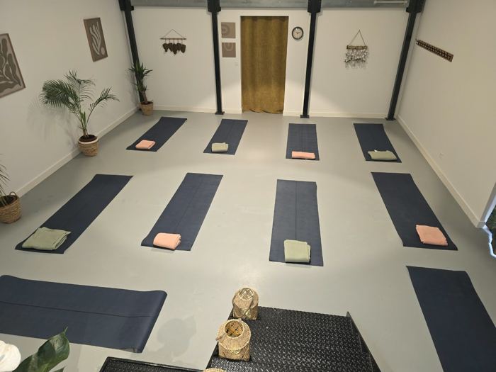 La salle installée avec des tapis et des plaids pour une séance collective